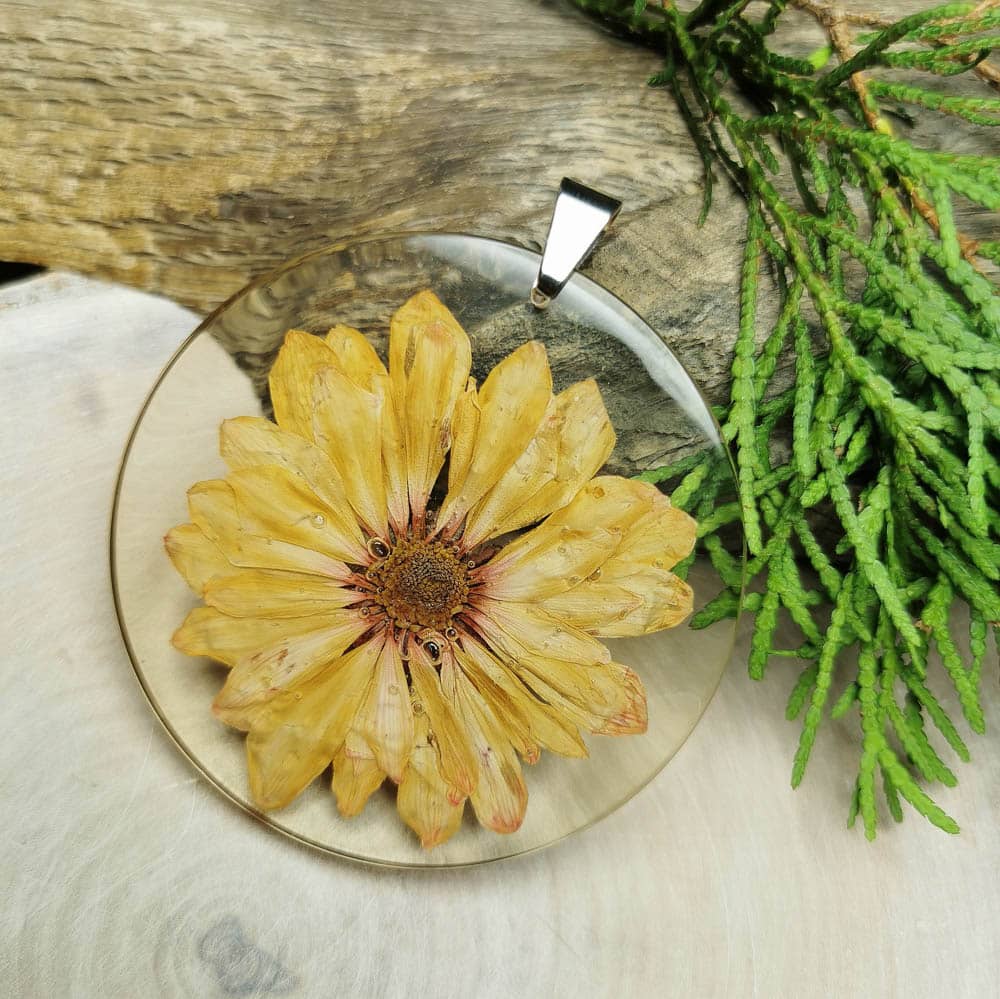 Okrągły wisiorek z żółtym kwiatem utrwalonym w żywicy