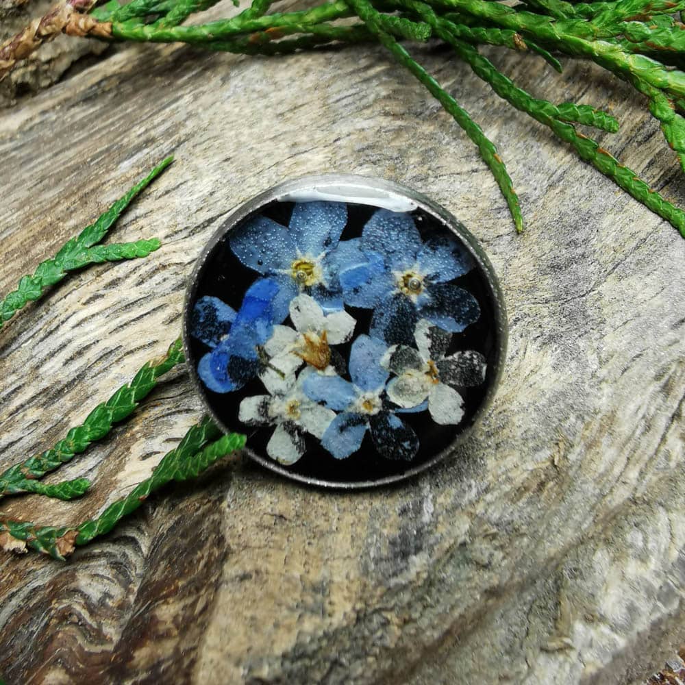 Okrągła przypinka z niebieskimi kwiatami
